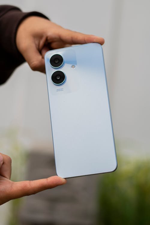 Gros plan d’un smartphone moderne posé sur une surface, mettant en évidence ses objectifs photo doubles et son design épuré